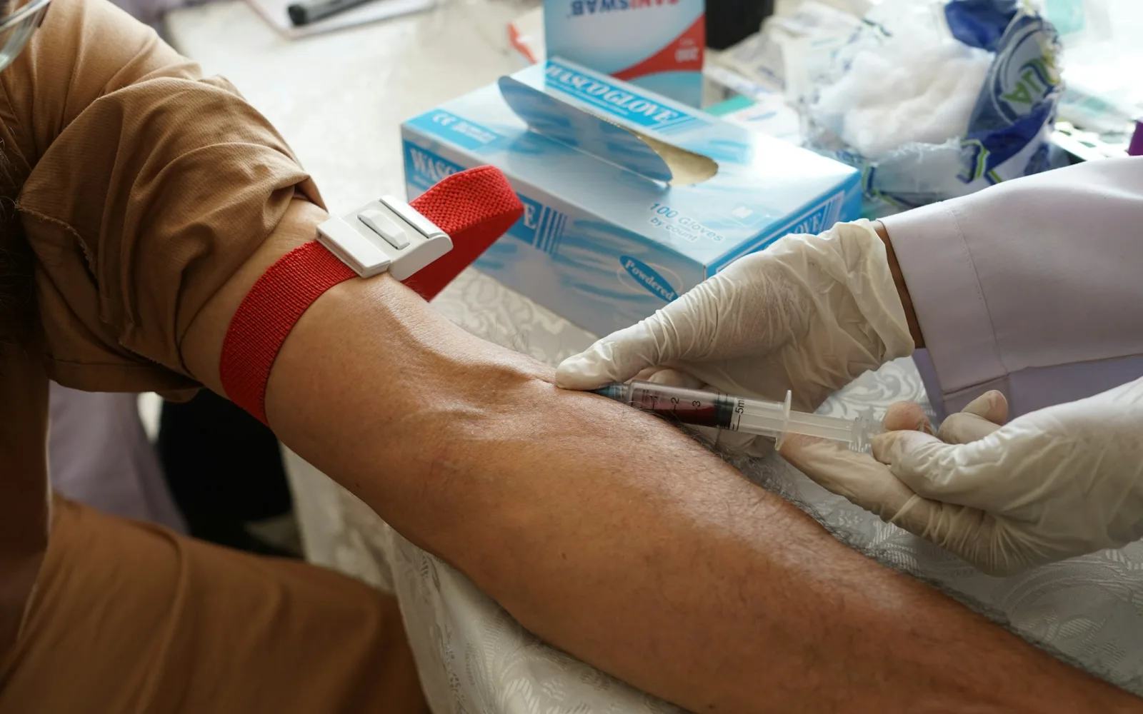 Phlebotomist drawing a blood sample from a patient’s arm