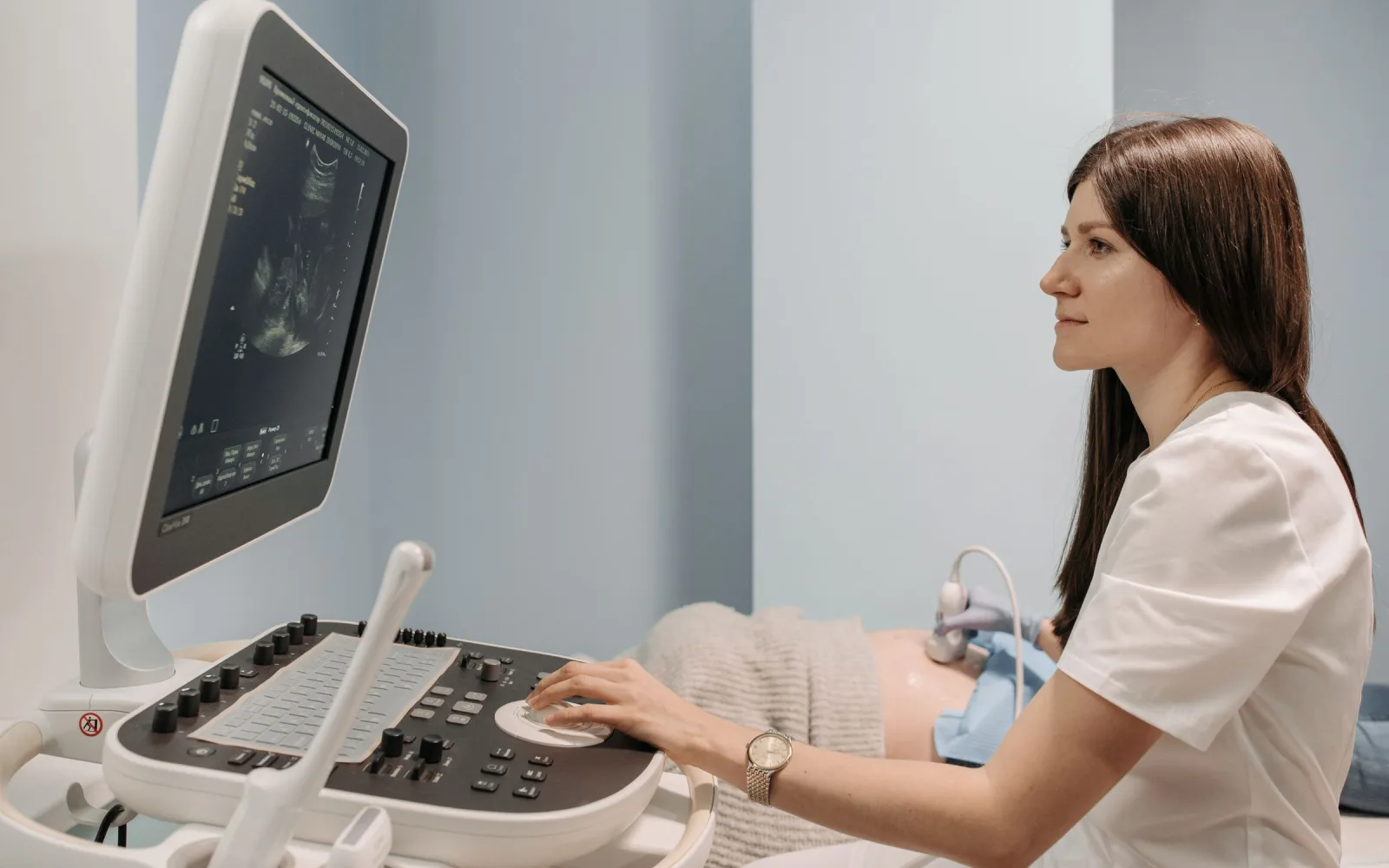 Sonographer scanning a patient on an ultrasound machine