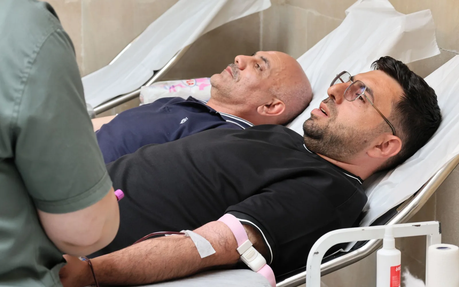 Patients reclining in treatment chairs with blood lines in place