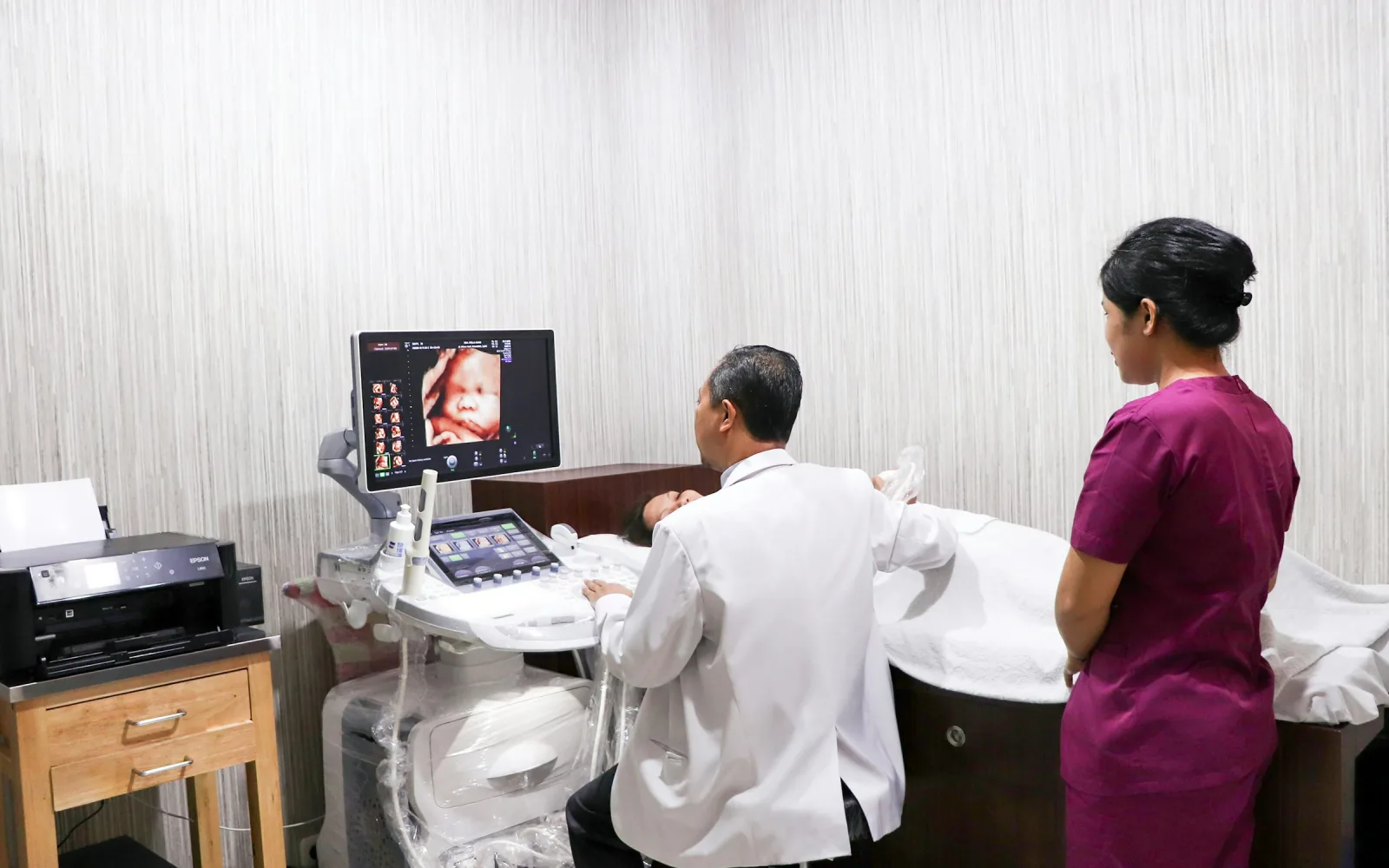 Doctor performing a pregnancy ultrasound with a nurse
