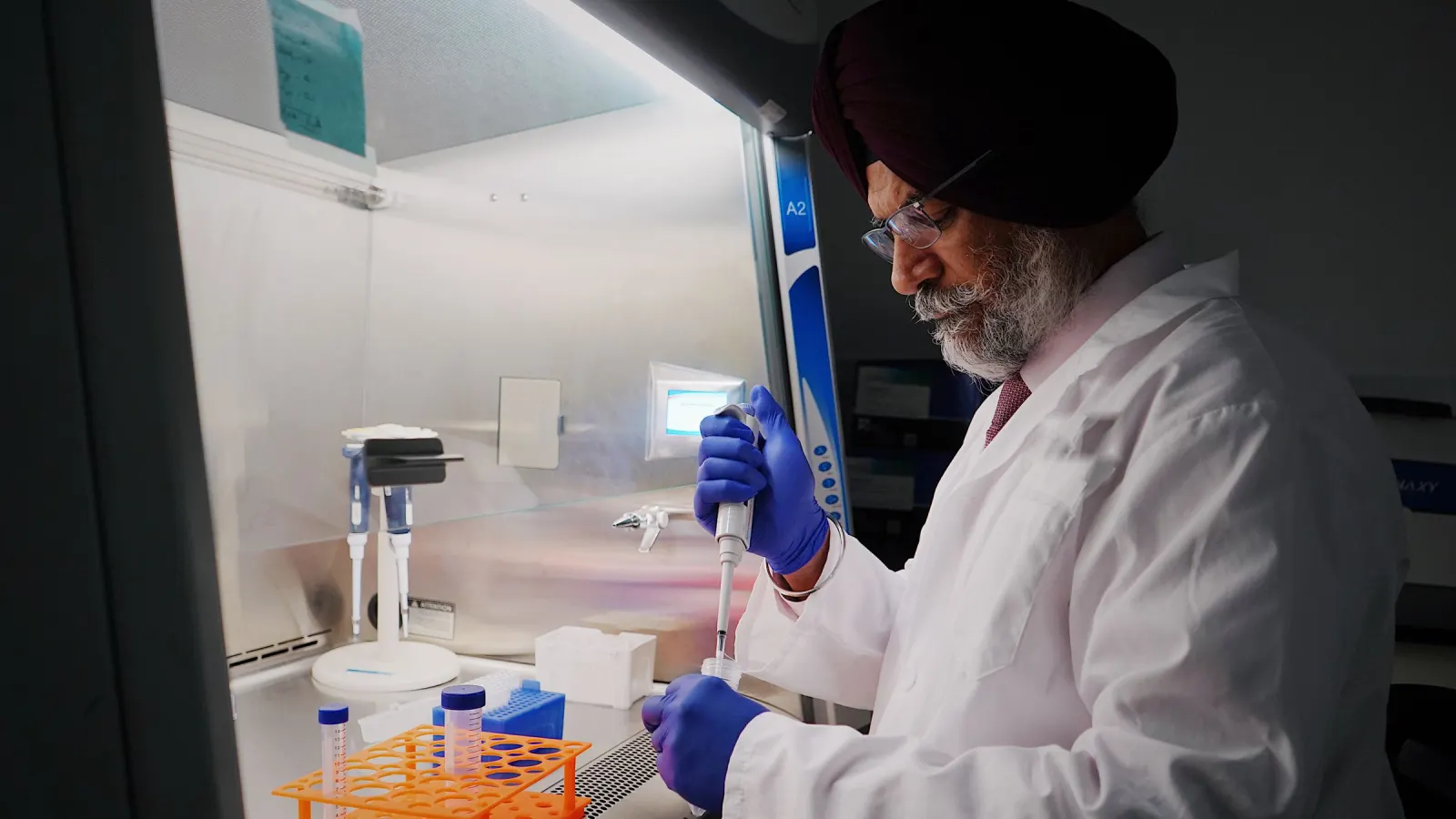 Laboratory scientist pipetting samples in a biosafety cabinet, representing pathology at Lucknow Imaging Centre